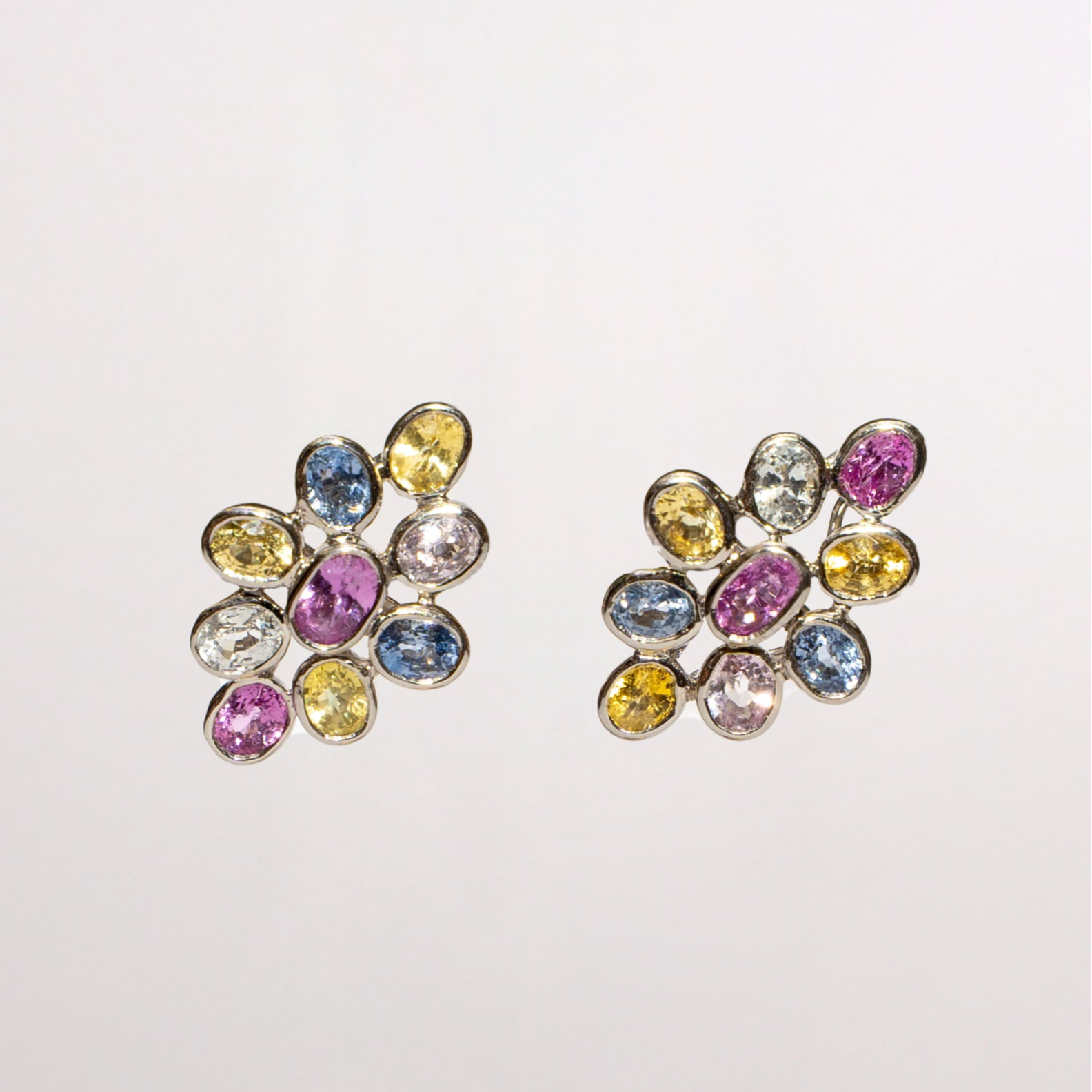 Pair of multicolored sahppire earrings on a light gray background