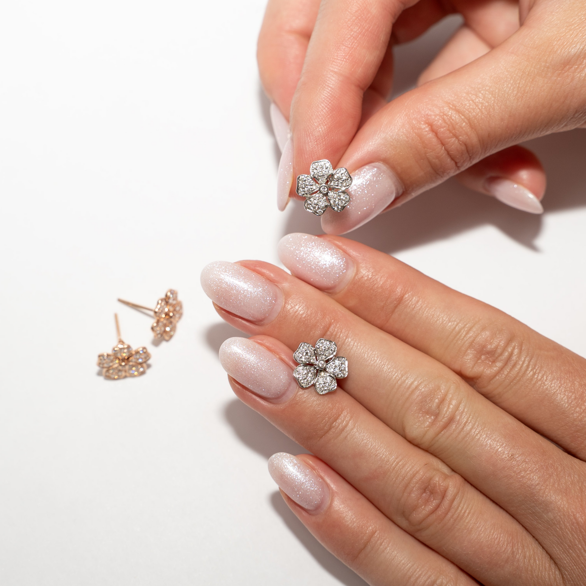 Flower earrings diamond on a hand with a white background